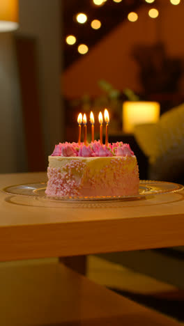 Vertical-Video-Of-Party-Celebration-Cake-For-Birthday-Decorated-With-Icing-And-Candles-On-Table-At-Home